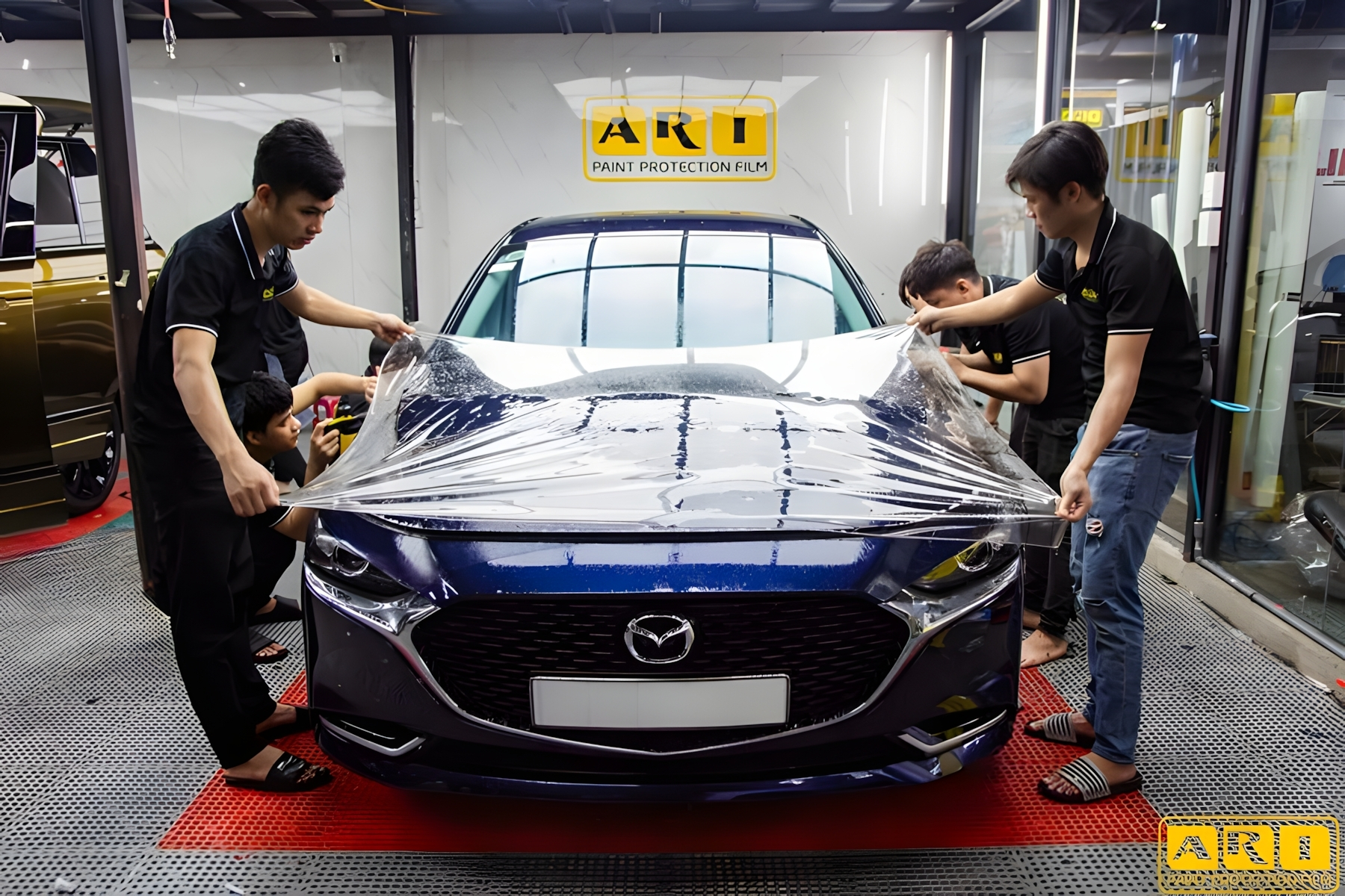 mazda 3 đã dán đang được kỹ thuật viên dán phim ppf ari độ sáng bóng cao